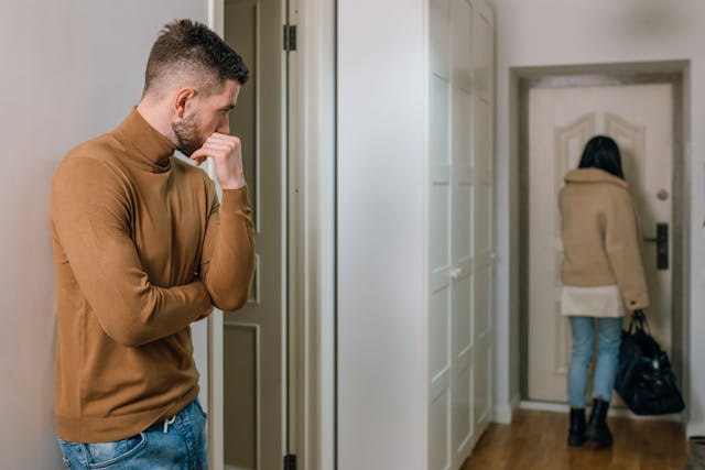 Vrouw loopt rustig weg terwijl haar ex haar nakijkt. Ze geeft haar ex wat hij wil en nu twijfelt hij, omkeerpsychologie in actie.