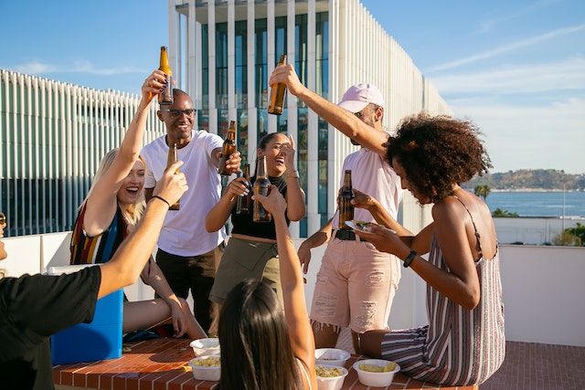 Een groep vrienden die proost en geniet van het mooie weer. Dit soort positieve energie is woest aantrekkelijk voor je ex.