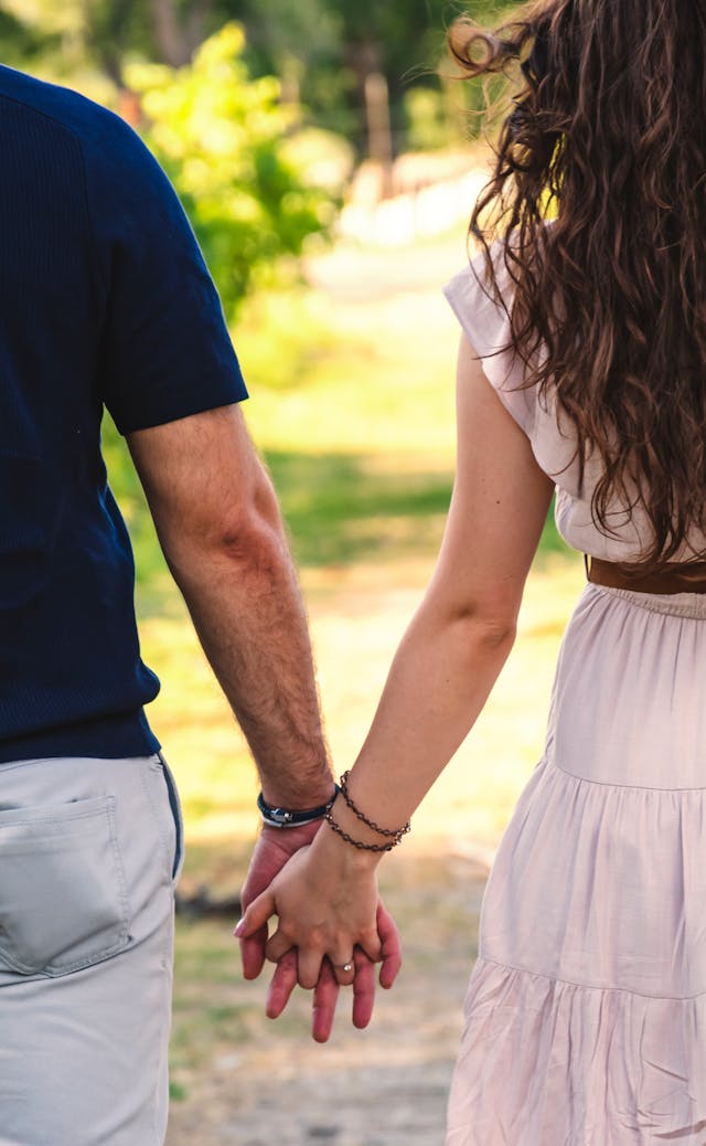 Twee mensen lopen hand in hand in het zonlicht, op weg naar verzoening en een nieuwe start samen.